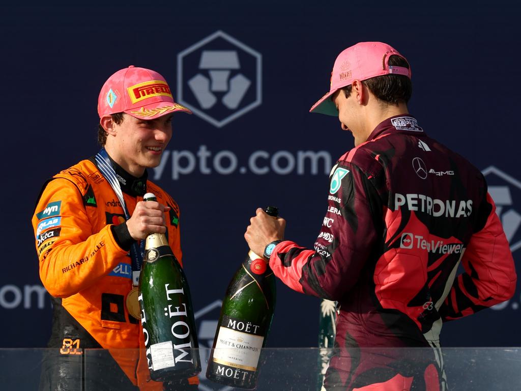 Race winner Oscar Piastri of Australia and McLaren and third placed George Russell of Great Britain, driving for Mercedes AMG Petronas, celebrate on the podium. Picture: Clive Rose/Getty Images)