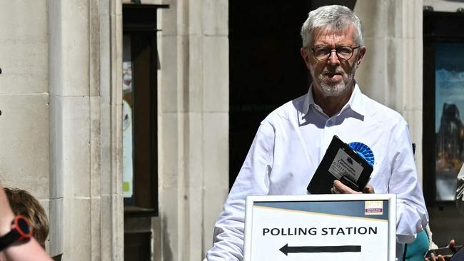 A Conservative Party campaigner stands at the entrance of a polling station in London during last month’s election. Picture: AFP