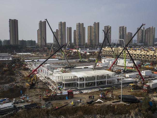 Hundreds of construction workers and heavy machinery build new hospitals to tackle the coronavirus in China. Picture: Getty Images