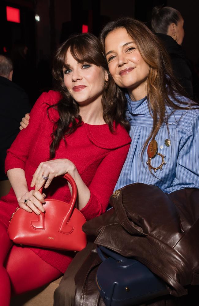 Famous friends Zooey Deschanel and Katie Holmes cuddle up in the front row at the Patou Menswear show. Picture: Arnold Jerocki/Getty Images for Patou