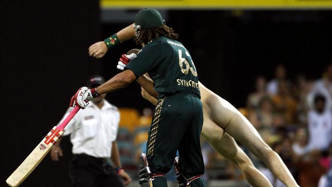 Australia's Andrew Symonds levels a streaker mid-match with a shoulder charge. Picture: AFP