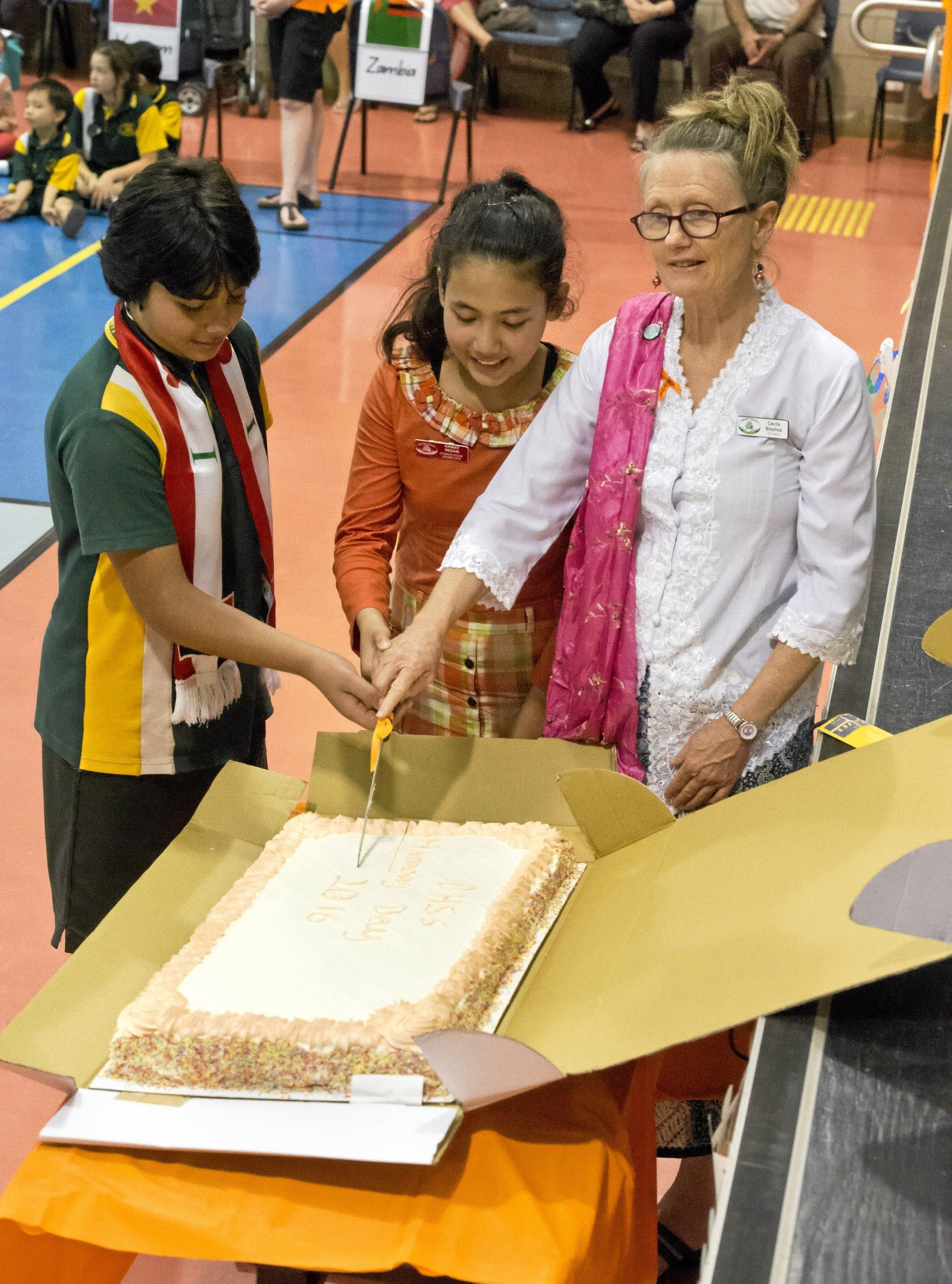 Abdullah Al- Halfi and Kainat Rezaie cut the cake with Cecily Bisshop. Harmony day at Darling Heights State School  . Wednesday 16 Mar , 2016. Picture: Nev Madsen