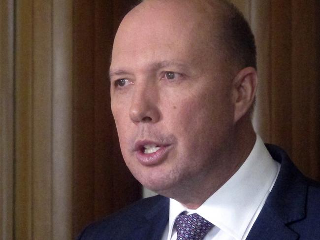 FILE - In this June 21, 2017, file photo, Australia's Immigration and Border Protection Minister Peter Dutton speaks to reporters at Parliament House in Canberra, Australia. Australia continued to work effectively with Cambodia, Dutton said on Wednesday, Feb. 21, 2018 after news that a murdered Cambodian political activistâ€™s family had been accepted as refugees. (AP Photo/Rod McGuirk, File)