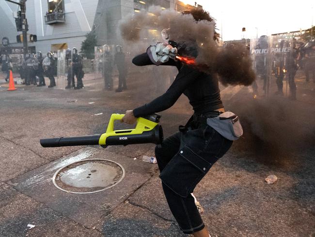 A protester throws a smoke device at police in Atlanta during a protest over the death of George Floyd. Picture: AP