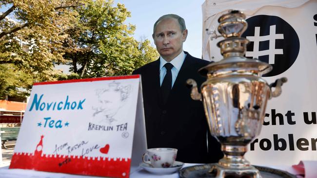 A mock offer of ‘Novichok Tea’ is seen in front of an effigy of Russian President Vladimir Putin outside the Russian embassy in Berlin during an anti-government protest. Picture: AFP