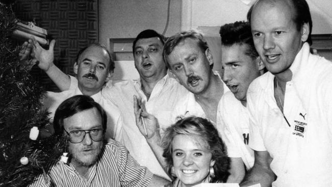 NWS9 Channel 9 television station. Channel 9 newsroom staff singing Christmas Carols to telephone callers. News Editor Bob Perry and reporter Georgina Allen sitting (McGuinness). (Back l-r) reporter Tom Menzies, Chief of Staff John Doherty, news producer Tim Parker, film editor Grant Anderson and reporter John Riddell circa 1988. (Pic by Robert Mayne PR, Frewville)