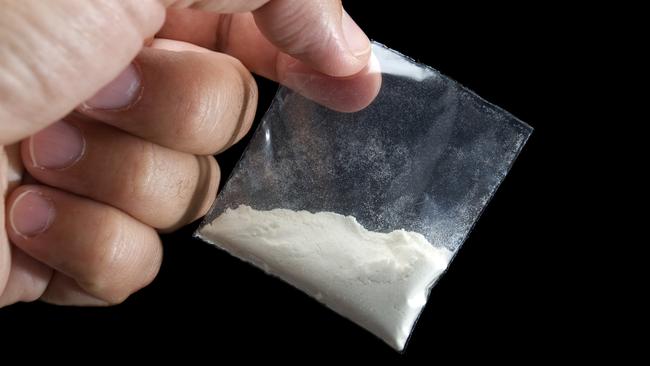 A man holding a bag of cocaine.