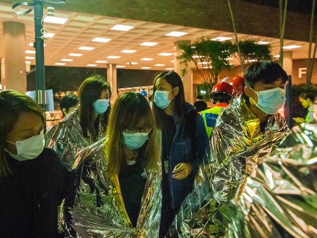 Injured protesters wrapped in emergency thermal blankets leave the campus of the Hong Kong Polytechnic University. Picture: Getty Images