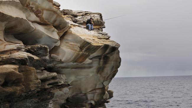 A man fishes from the top of a cliff in Maroubra. Photo: Simon Chillingworth