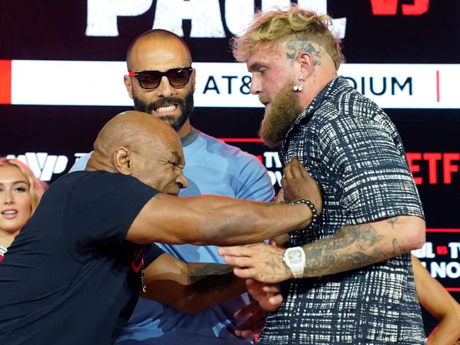 (L-R) Former US heavyweight boxing champion Mike Tyson and US YouTuber and boxer Jake Paul face off during a press conference at Fanatics Fest NYC on August 18, 2024, in New York City. The heavyweight match has been rescheduled for November 15, 2024, and will take place in Arlington, Texas. (Photo by TIMOTHY A. CLARY / AFP)