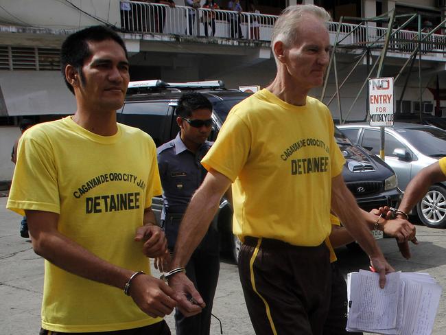 Scully, right, leaves court handcuffed to another detainee.  Picture: AFP