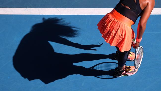 Shadow-play: Osaka coaxes the butterfly onto her fingers. Picture: David Gray