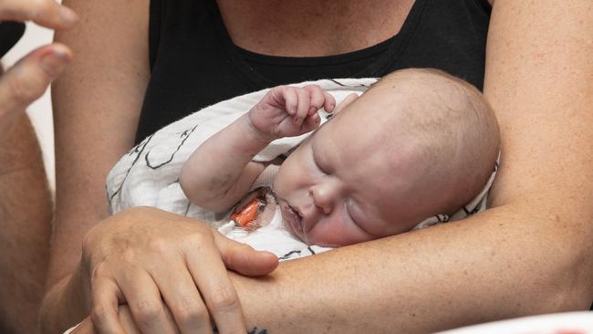 Kirsten Haran holds her baby boy Regan (9 weeks) before he has his fingerprints pressed to a piece of canvas. Picture: Monique Harmer