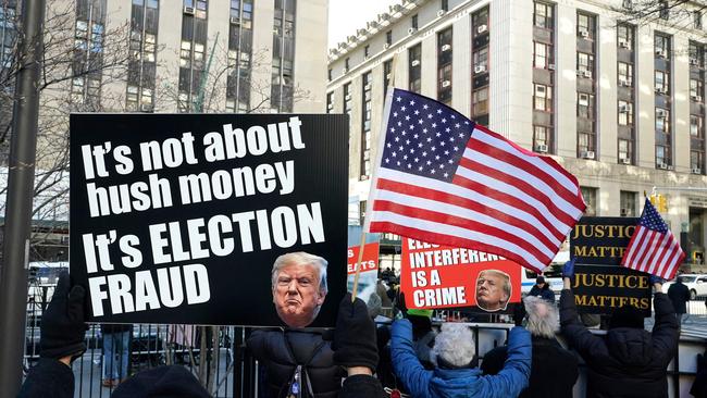 Protesters hold up signs outside the Manhattan Criminal Court as Donald Trump attends during the week. Picture: AFP