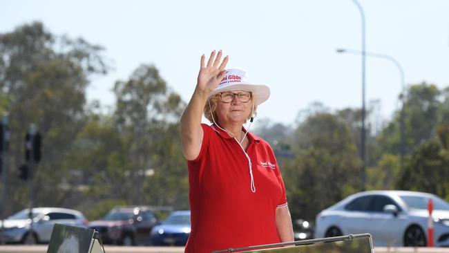 Council candidate Toni Gibbs waves to traffic near the One Mile bridge on Thursday morning.