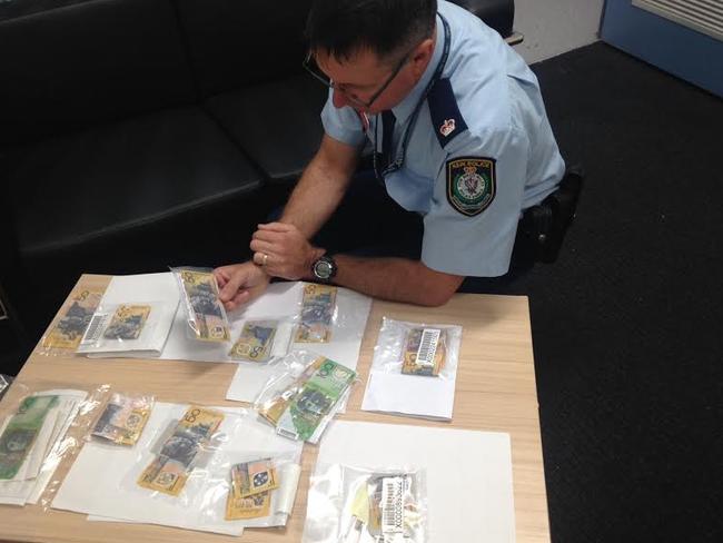 Inspector Jim Szabo with a number of fake counterfeit $50 and $100 notes handed in to Castle Hill Police.