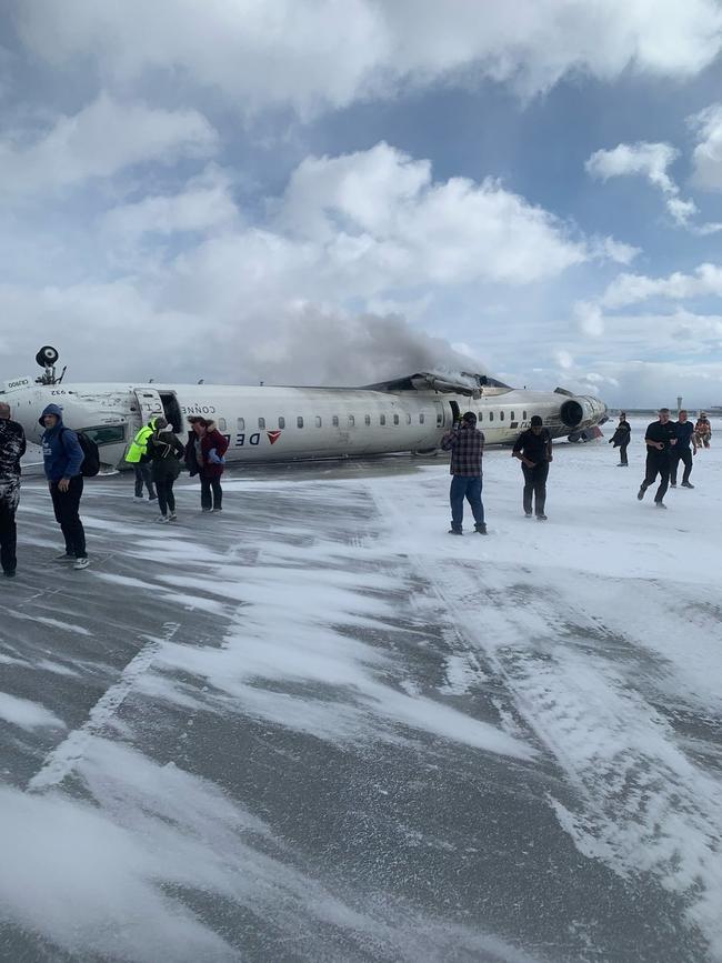 Passengers exit the Delta plane which flipped on the runway.