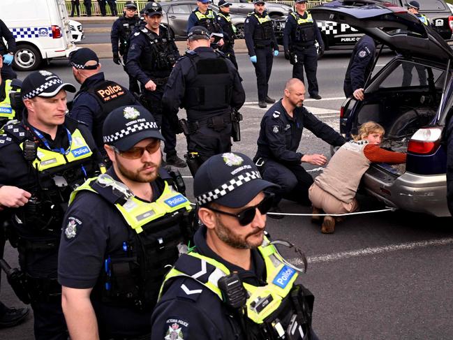 Police officers detain a protester blocking a road outside the Land Forces weapons expo on September 13. Picture: AFP