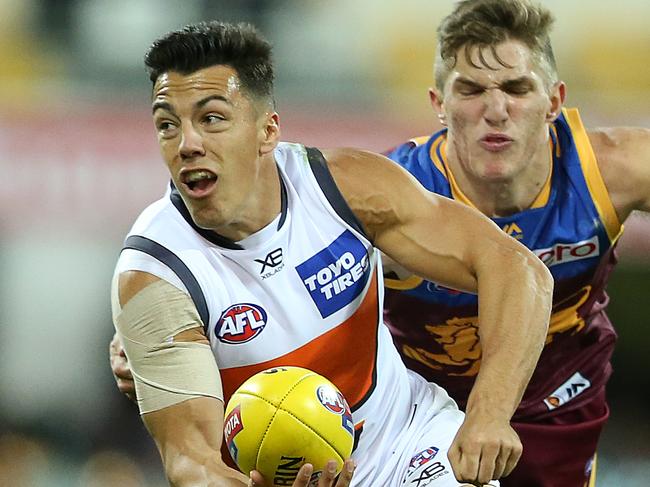 BRISBANE, AUSTRALIA - JUNE 23: Dylan Shiel of the Giants looks to handball past Zac Bailey of the Lions during the round 14 AFL match between the Brisbane Lions and the Greater Western Sydney Giants at The Gabba on June 23, 2018 in Brisbane, Australia. (Photo by Jono Searle/Getty Images)