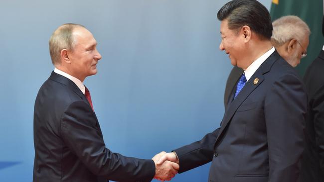 Chinese President Xi Jinping and Russian President Vladimir Putin shake hands before the Dialogue of Emerging Market and Developing Countries 2017. Picture: AFP Photo/Kenzaburo Fukuhara