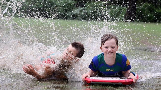 Finn McGahan and Matthew Travers having fun in the wet at Ashgrove. Picture: AAP/Richard Gosling