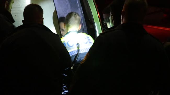 Police take the driver away for questioning following his arrest. Picture: Damian Hofman.