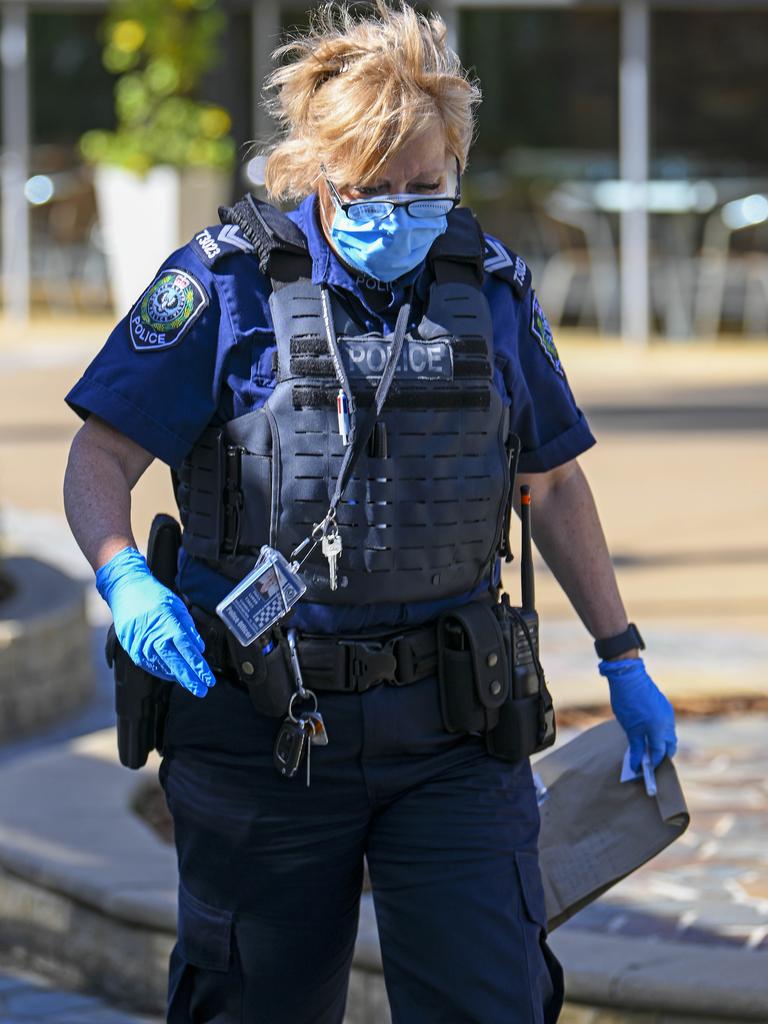 A crime-scene investigator carries evidence from the scene of the stabbing. Picture: Mark Brake