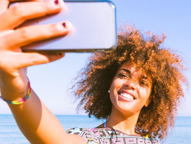 Young woman taking a selfie at beach. Picture: iStock