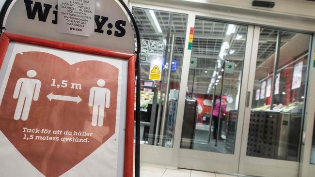 A sign reminds customers about social distancing at the entrance to a grocery store in central Stockholm. Picture: Amir Nabizadeh/AFP