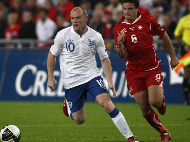 Switzerland's Pirmin Schwegler, right, looks to challenge England striker Wayne Rooney in a 2010 World Cup qualifier. Picture: AP