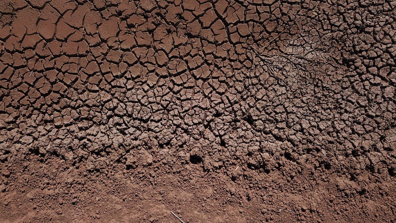 The cracked bed of a water canal between Pooncarie and Menindee — one stark illustration of the consequences of the crippling drought. Picture: AAP