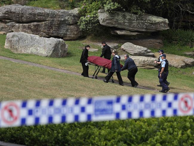 Police and morticians wheel the body away from the scene. Picture: Max Mason-Hubers