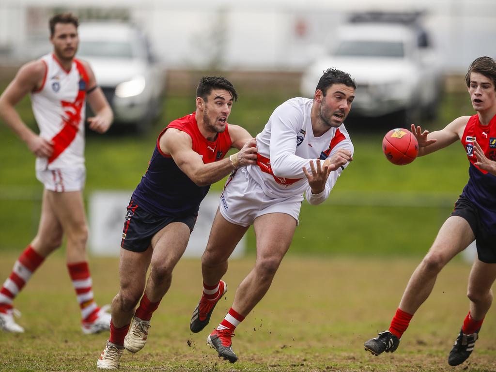 Sorrento’s Josh Iezzi gets a handball away during a wet clash against Mt Eliza. Picture: Valeriu Campan