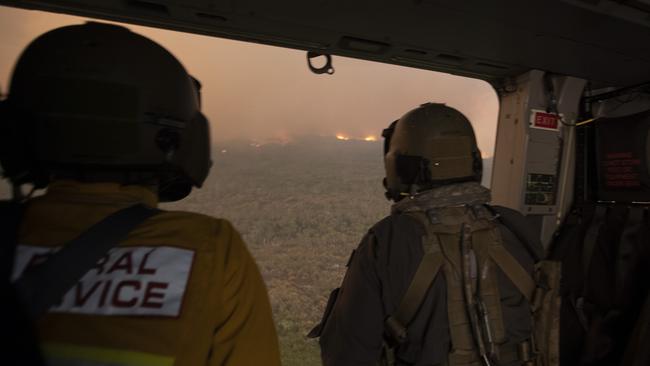 Rural Fire Service employee Dwyane Graham and Royal Australian Navy Aircrewman Leading Seaman Brendan Menz view the Tianjara bushfire.