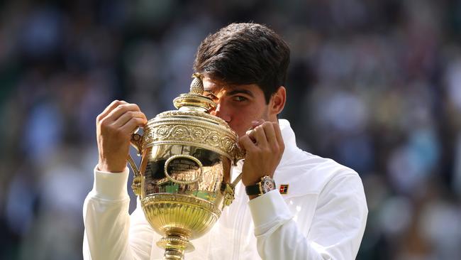 LONDON, ENGLAND - JULY 14: Carlos Alcaraz of Spain kisses the Gentlemen's Singles Trophy following victory against Novak Djokovic. (Photo by Julian Finney/Getty Images)