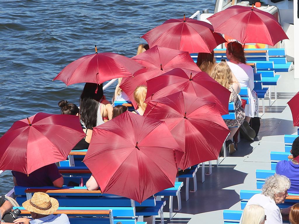 Tourists protect themselves from the sun with umbrellas on a boat on the Spree river in Berlin, Germany on July 1, 2015. The European weather forecast is predicting high temperatures for the next few days. Picture: AP