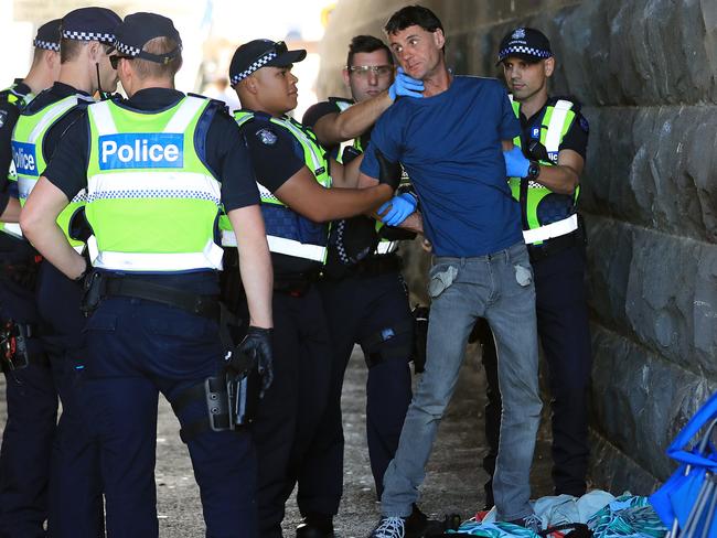 Police officers question the man before he is forced up against Princess Bridge and searched. Picture: Alex Coppel