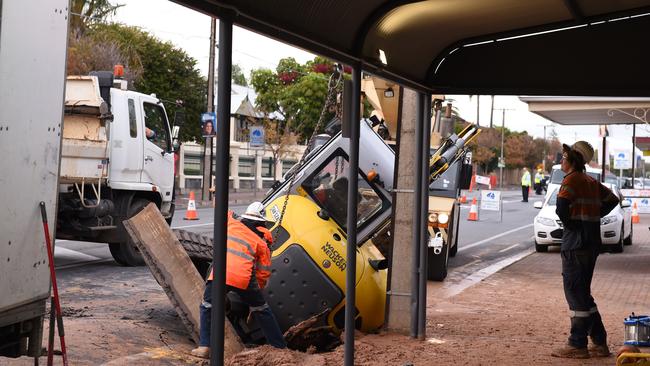 An excavator fell into a hole caused by a burst water main on Prospect Rd in Prospect on Friday morning. Photo: Naomi Jellicoe