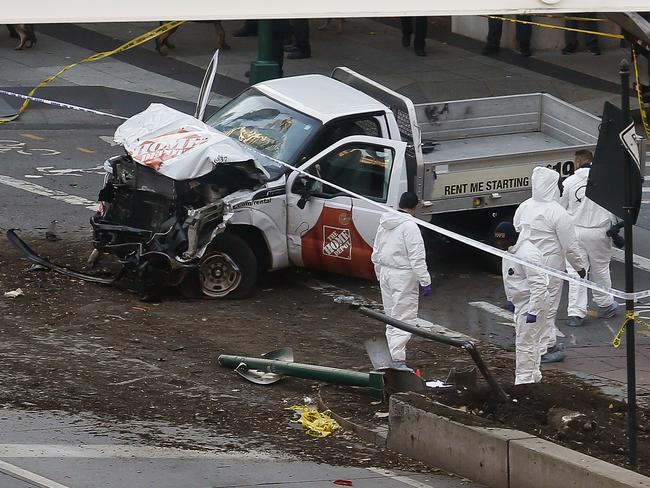 Authorities stand near the ute used to mow down cyclists and pedestrians. Picture: AP