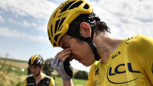 Great Britain's Geraint Thomas cleans his stinging eyes after tear gas was used during a farmers' protest who attempted to block the stage's route, during the 16th stage of the 105th edition of the Tour de France cycling race, between Carcassonne and Bagneres-de-Luchon, southwestern France, on July 24, 2018. The race was halted for several minutes on July 24 after tear gas was used as protesting farmers attempted to block the route. / AFP PHOTO / Marco BERTORELLO