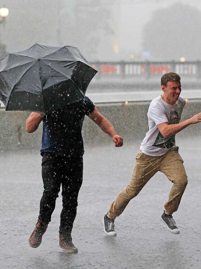 Two men make a dash towards shelter. Picture: Mark Stewart