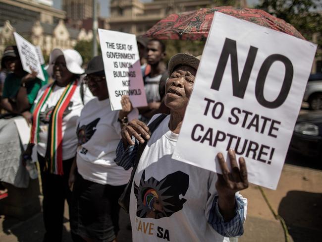 A woman holds a placard as she chants slogans during a rally outside the South African National Treasury on April 3, 2017, in Pretoria called by “Save SA” civil organisation, opposition parties, Unions members and supporters to protest against South African president Jacob Zuma and his recent Cabinet re-shuffle.  A memorial service on April 1, 2017 for anti-apartheid icon Ahmed Kathrada was transformed into a fierce attack on South African President Jacob Zuma, under fire after a controversial cabinet reshuffle. Party veterans of the ruling ANC, sacked finance minister Pravin Gordhan and Kathrada's widow lined up to criticise the state of the country as the crowd shouted "Zuma must go."  / AFP PHOTO / GIANLUIGI GUERCIA