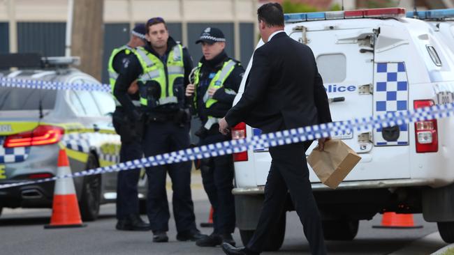 A detective bags up evidence at the scene. Picture: David Crosling