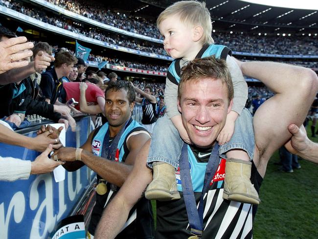 Jarrad Schofield and his son Taj after the 2004 Grand Final win.