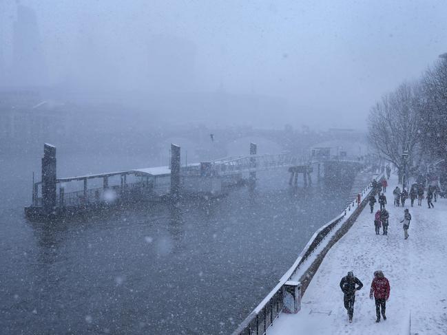 Pedestrians walk along the south bank of the river Thames as heavy snowfall hits London on February 27, 2018. A blast of Siberian weather sent temperatures plunging across much of Europe on Tuesday, causing headaches for travellers and leading to several deaths from exposure as snow carpeted palm-lined Mediterranean beaches. Picture: AFP