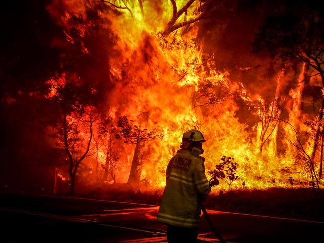 SYDNEY, AUSTRALIA - DECEMBER 19: Fire and Rescue personal prepare to use a hose in an effort to extinguish a bushfire as it burns near homes on the outskirts of the town of Bilpin on December 19, 2019 in Sydney, Australia.   (Photo by David Gray/Getty Images)