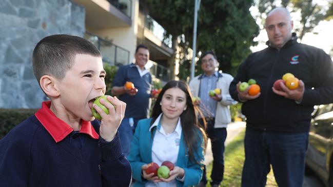 Freddy Sarkis, 6, with an apple. His father, Cumberland councillor Eddy (far right), wants to introduce fruit trees on nature strips. Also pictured is Lamissa Sarkis and (back, left to right) David Isaac and Val Moran at Pemulwuy. Picture: Angelo Velardo