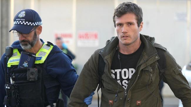 Chris Delforce is escorted by police. Picture: Farm Transparency Project