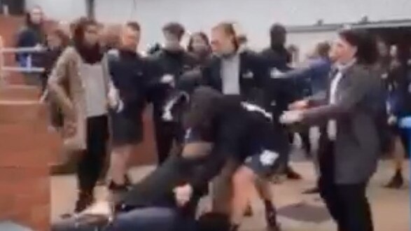 A still from shocking footage showing a 16-year-old student being held on the ground in a headlock by a staff member after a violent brawl at Berwick Secondary College.