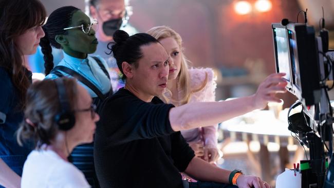 Cynthia Erivo (as Elphaba), Director Jon M. Chu, and Ariana Granda (as Glinda) on the set of Wicked.